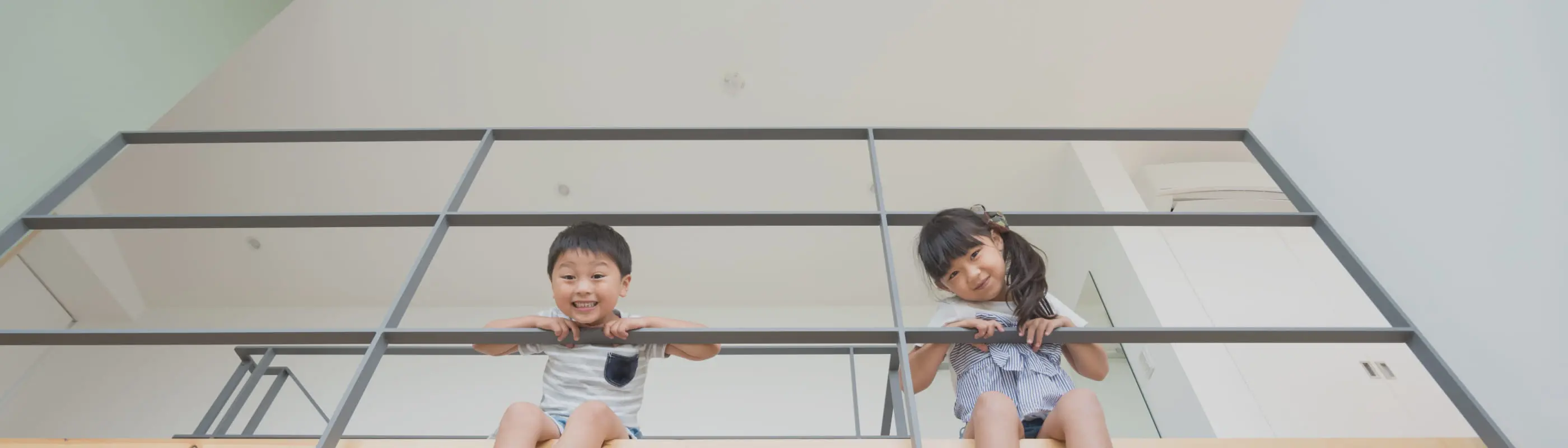 ガラスの手すりに寄りかかる子供たちの写真