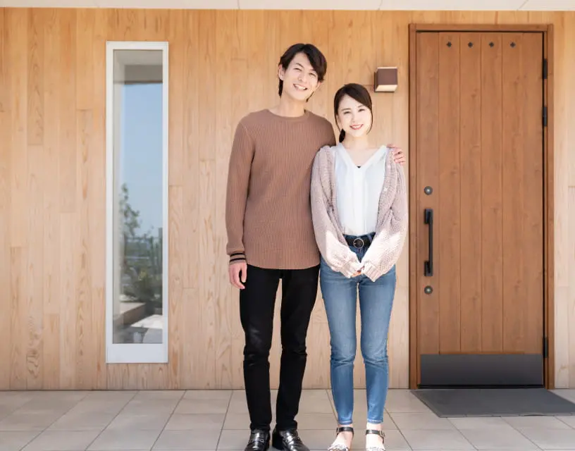 玄関前でポーズをとる夫婦の写真